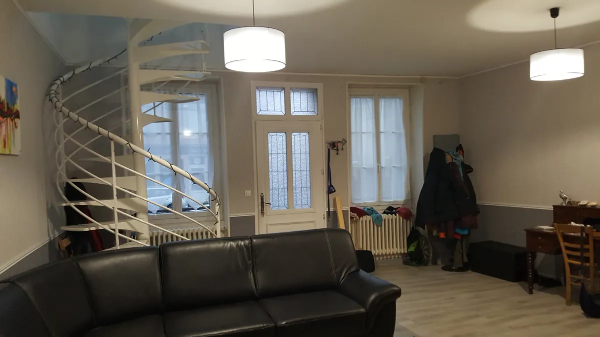 Pièce de vie avec un escalier hélicoïdal blanc, avant les travaux